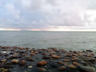 in the photo, wet pebbles on the background of the sea