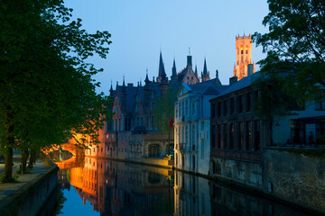 Illuminated buildings and bridge reflecting in the water at night, Historic centre of Bruges, Belgium, Unesco World Heritage Site.