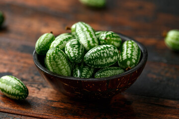Freshly picked Cucamelon in rustic bowl on wooden table