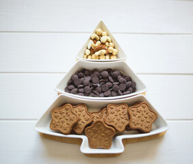 Christmas tree dish with nuts, chocolate and gingerbread cookies
