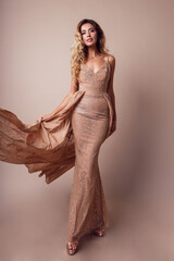  Full length  image of amazing luxury seductive woman in stylish  dress posing in studio on beige...