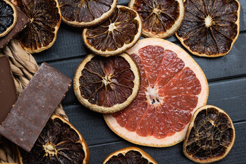 still life of citrus and chocolate. Grapefruits and oranges are cut into circles. Dried citrus fruits.