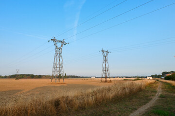 Group of electric pylons, high voltage lines. Overhead cables carrying electricity to cities.