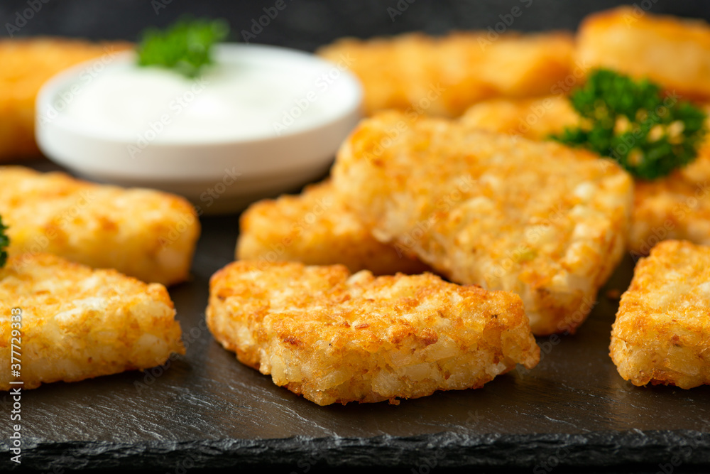 Wall mural Hash brown potato patties on rustic stone board