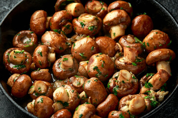 Fried mushrooms with onion and garlic in iron cast pan
