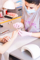 Obraz na płótnie Canvas Manicure master edged hygienic manicure with a professional tool.