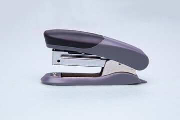 Stapler on a green background. Stationery. Office tool.