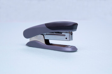 Stapler on a green background. Stationery. Office tool.
