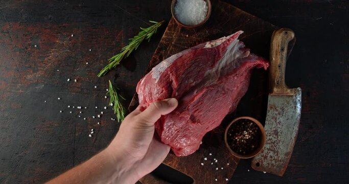 A piece of beef is put on the cutting board.