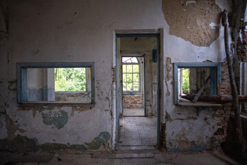 Fototapeta na wymiar Inside abandoned house. View on broken window with curtain. Grunge scene
