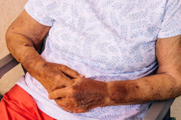 An old woman sitting with her hands together