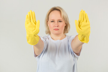 beautiful young plump woman in a white t-shirt on a white background in rubber gloves