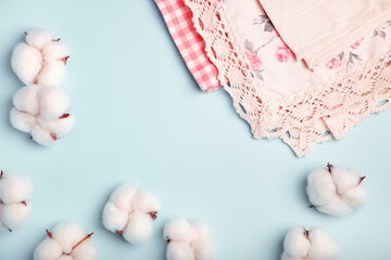 Cotton bolls and napkins made of cotton fabric on a blue background