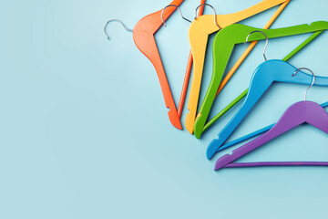 Multi-colored clothes hangers on a blue background. Concept of shopping and sale.