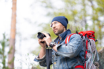 Middle aged bearded male hiker with photocamera.