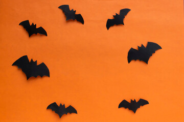Happy Halloween holiday concept. Halloween decorations, frame of bats on an orange background. The layout of the greeting card
