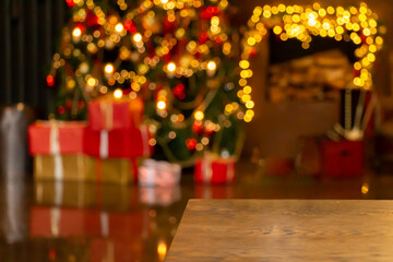 Dark Christmas and New year background with empty dark wooden table over christmas tree and blurred light bokeh. Empty display for product montage. Rustic vintage Xmas background.