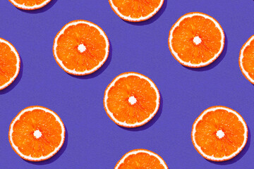 Top view of fresh bloody orange pattern on purple background. Many sliced red orange texture background. Fruit minimal concept.