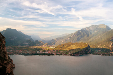 Lake coast with town Riva del Garda and mountains and cliffs around, in the foreground lake - Lago di Garda, Italy