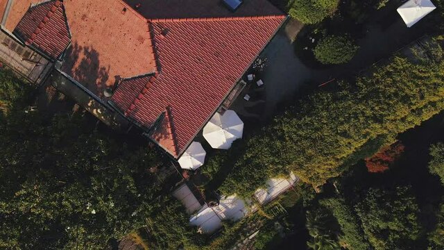 Aerial Drone Shot Spiraling Upwards Revealing A Beautiful Hotel in The Town of Ranco on Lake Maggiore in Italy on A Beautiful Summers Afternoon