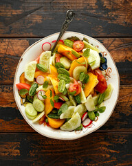 vegetarian vegan salad with crystal lemon cucumbers, cucamelon, radishes and orange tomato. Healthy food concept