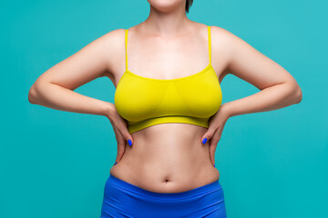 Woman in yellow top bra with big natural breasts on blue background
