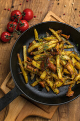 Fried potatoes with mushrooms from the menu of a Ukrainian restaurant. On a wooden table
