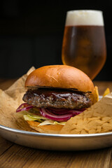 Hamburger from the menu of an American restaurant. On a wooden table
