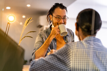 Two asian businessmen discuss while coffee break in common zone.
