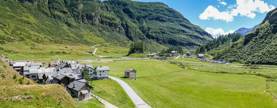 small village in the mountains with stone houses, flowers and a river in val formazza