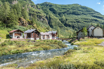 Fototapeta na wymiar small village in the mountains with stone houses, flowers and a river in val formazza