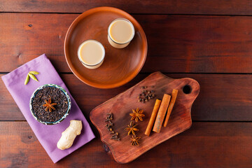 Tea with milk and spices. Indian masala chai tea on wooden boards. Autumn drink in turkish tea cups. Top view