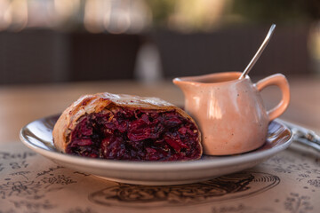 Sliced homemade strudel with cherry close-up on a plate. horizontal