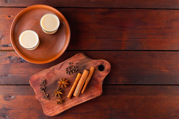 Tea with milk and spices. Indian masala chai tea on wooden boards. Autumn drink in turkish tea cups. Top view