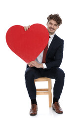 young businessman holding a big red heart in his hands