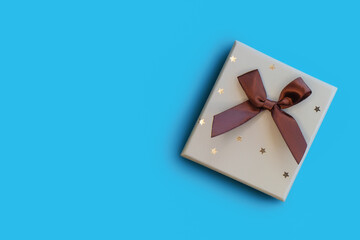 Christmas gift box with bow on blue background