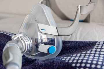 CPAP mask against obstructive sleep apnea on pillow helps patients as respirator mask and headgear clip for breathing medication with a cpap machine against snoring and sleep disorder to breath easier