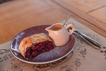 Sliced homemade strudel with cherry close-up on a plate. horizontal