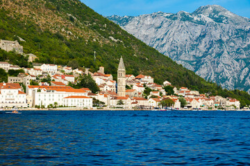 View of the city of Perast from the sea against the backdrop of high green mountains