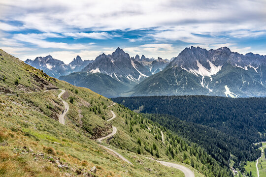 nice and active senior woman riding her electric mountain bike on a old military road from Toblach upt to the summit of Marchkinkele eith spectacular view to the Three peaks of Lavaredo, South Tirol, 