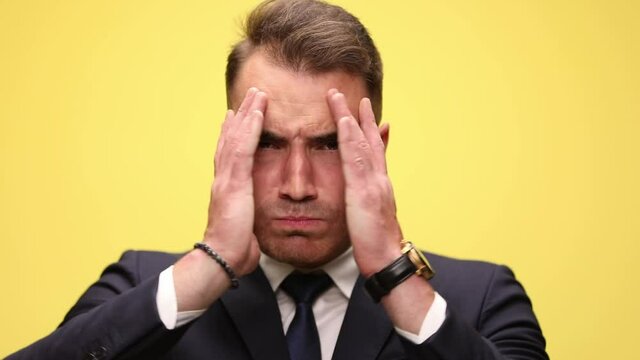 businessman being shocked, slapping his face, opening his hands and having an angry face then a surprised one, covering again, lifting hands and making a happily surprised face