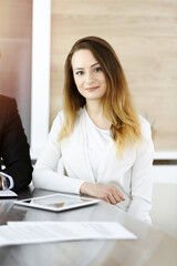 Business woman headshot in sunny office. Unknown businesswoman sitting behind computer monitor