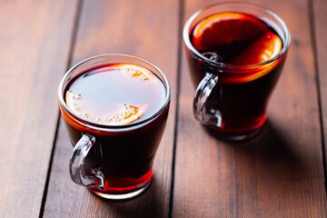 Mulled wine on wooden background. Winter drink traditional for the Christmas holidays. Two glasses of Christmas mulled wine with oranges