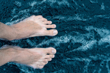 Male feet on black sand beach shore