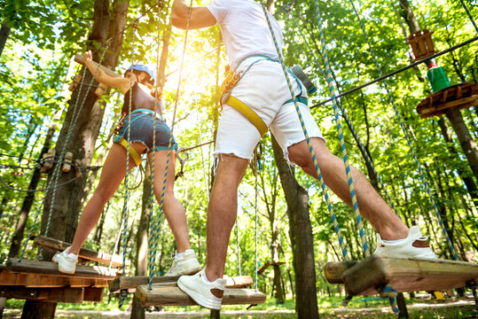 Young couple having fun time in adventure rope park.