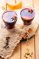 Mulled wine on a wooden background. Autumn mulled wine and spices on burlap. Christmas hot drink in rustic style