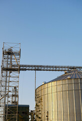 Fototapeta premium Steel grain elevator close up. Agriculture business. Cereals storage. Vertical orientation 
