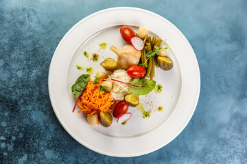 Slices various pickled vegetables on white plate in restaurant