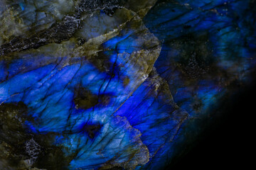 shining blue gemstone labradorite on a black background