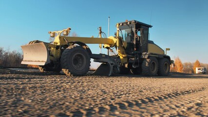 Grader with 3D GPS System. Satellite navigation. A motor grader levels bulk building materials for a new road construction. Road surface repair. Road construction machines. Road works